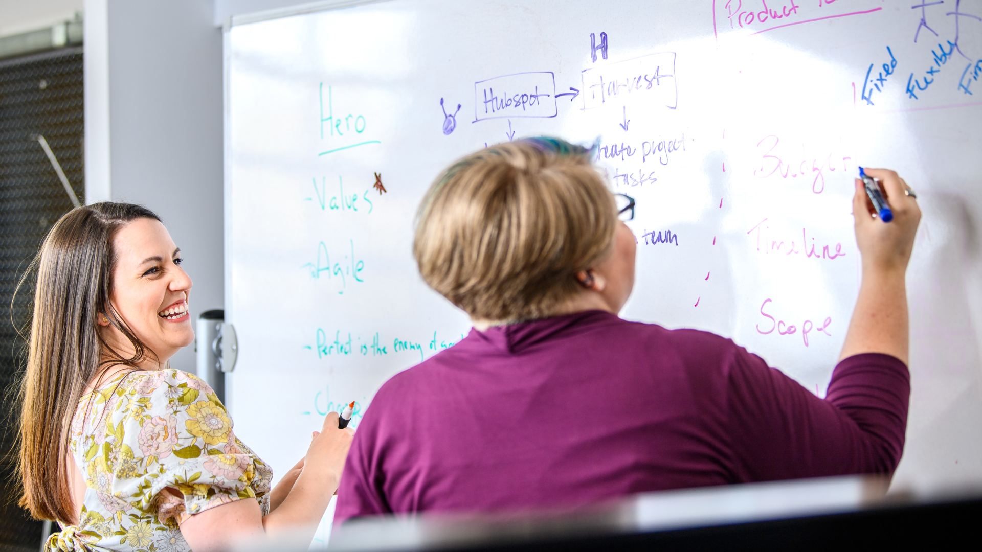 Two experience design consultants collaborating on great customer experience in front of a whiteboard.